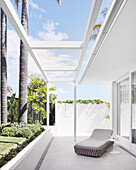 Elegant lounger and side table on partly covered terrace