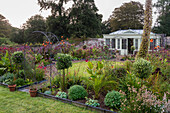 Garten mit eingefassten Betten und Bögen am Sommerhaus