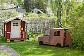 Playhouse in the shape of an old van and wooden chalet playhouse in garden