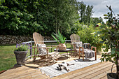 Sunny terrace place with two adirondack chairs and side table, dog lying on the outdoor rug