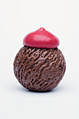Eine Kugel Schokoladeneis mit Himbeerhaube