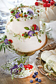White twotier cake decorated with wild flowers