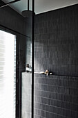 Duschbereich mit schwarzen Wandfliesen