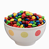 Colorful chocolate candies with a sugar shell in a ceramic bowl