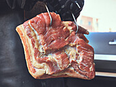 Selbstgepökelter Bacon an Fleischhaken