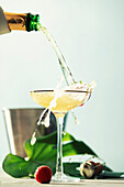 Pouring champagne into glass on blue sky background
