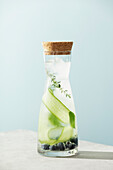 Summer drink in a bottle with cucumber, blackberry and thyme