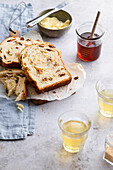 Cinnamon swirl raison bread served on a wooden board with tea honey and butter
