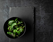 Small bowl of blistered padron peppers with maldon sea salt