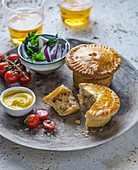 Pork Pies served on a plate with salad and mustard
