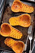 Chilli roasted butternut pumpkin halves on a baking tray