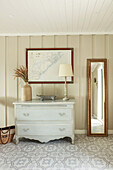 Gustavian chest of drawers on tiled floor with ornamental pattern in hallway