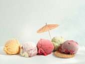 Five scoops of ice cream with a cocktail umbrella