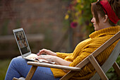 Woman using laptop in lawn chair