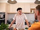 Gay male couple talking in kitchen