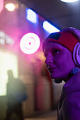 Woman with headphones in neon light