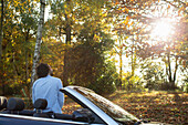 Man in convertible in sunny autumn park