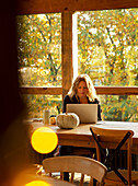 Businesswoman working on laptop in autumn cafe
