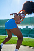 Female track and field athlete throwing discus