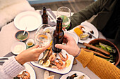 Couple toasting wine and beer over seafood lunch