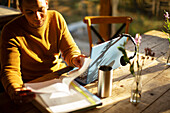 Businessman reviewing paperwork on laptop in cafe