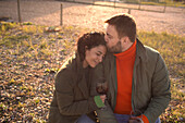 Happy affectionate couple drinking wine on sunny patio