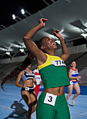 Happy female track and field athlete winning race