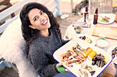 Happy woman with fresh seafood at patio table