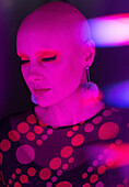 Stylish serene woman with shaved head in red light