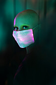 Woman with shaved head in glowing face mask