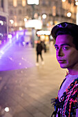 Young man on city street at night