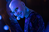 Woman with shaved head in blue neon light