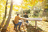 Businessmen meeting at table in sunny autumn park