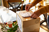 Business owner placing shipping label on cardboard box
