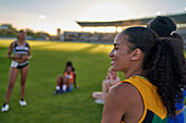Smiling female track and field athlete in stadium grass