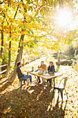 Business people having lunch meeting in sunny autumn park