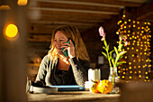 Happy businesswoman talking on smart phone working in cafe