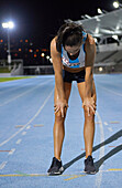 Exhausted female track and field athlete after race on track