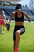 Female athlete practicing discus throw in grass