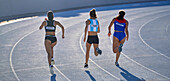 Female athletes running in competition on track