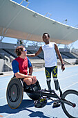 Happy amputee and paraplegic athlete on sports track