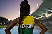 Female athlete with long black braids in stadium