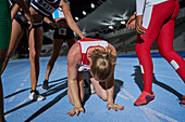Female athletes supporting tired runner on track