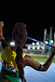 Female athlete with black braids throwing javelin