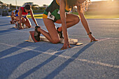 Female athletes ready at starting blocks on track