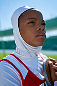 Determined athlete in hijab holding discus