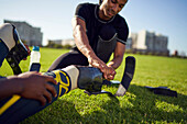 Coach helping amputee athlete with running blade prosthetics