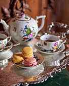 Macarons and elegant tea service on a silver tray