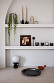 Minimalist ornaments on shelves in arched niche