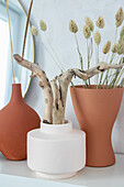 Mit selbstgemachter Kreidefarbe bemalte Vasen mit Treibholz